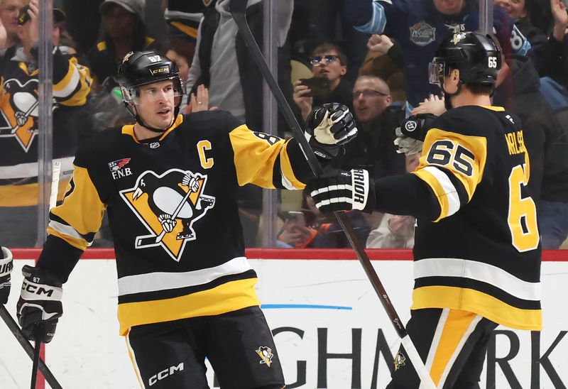 Dec 16, 2025; Pittsburgh, Pennsylvania, USA; Pittsburgh Penguins center Sidney Crosby (87) congratulates defenseman Erik Karlsson (65) on his goal against the Edmonton Oilers during the second period at PPG Paints Arena. Mandatory Credit: Charles LeClaire-Imagn Images
