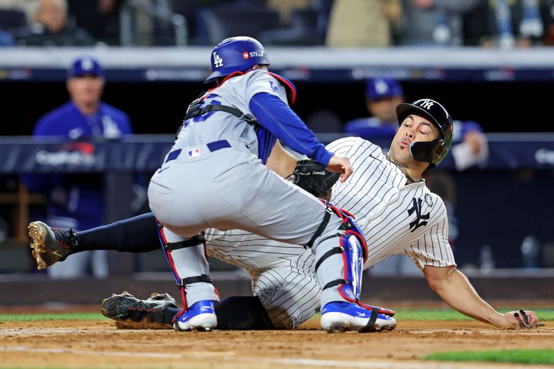 Oct 28, 2024; New York, New York, USA; Los Angeles Dodgers catcher Will Smith (16) tags out New York Yankees designated hitter Giancarlo Stanton (27) at home plate during the fourth inning in game three of the 2024 MLB World Series at Yankee Stadium. Mandatory Credit: Brad Penner-Imagn Images