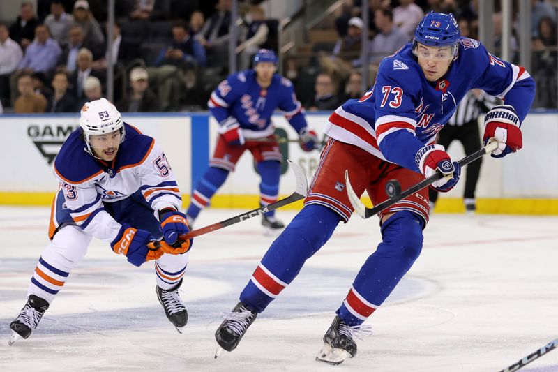 Oct 14, 2025; New York, New York, USA; New York Rangers center Matt Rempe (73) plays the puck against Edmonton Oilers left wing Isaac Howard (53) during the third period at Madison Square Garden. Mandatory Credit: Brad Penner-Imagn Images