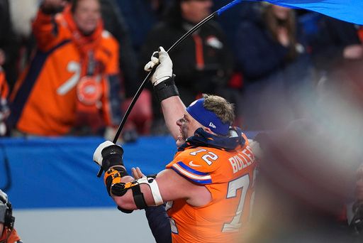 Denver Broncos offensive tackle Garett Bolles waves a team flag after an NFL football game against the Kansas City Chiefs, Sunday, Jan. 5, 2025, in Denver. (AP Photo/David Zalubowski)