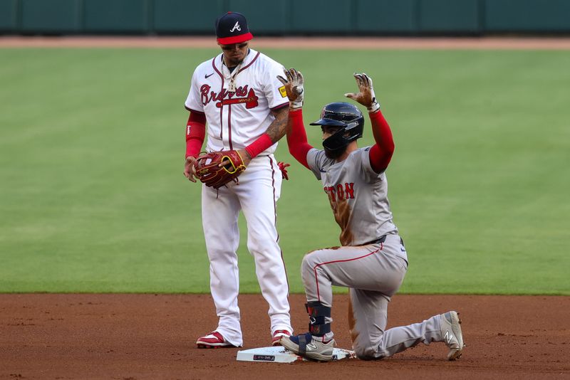 May 8, 2024; Atlanta, Georgia, USA; Boston Red Sox catcher Connor Wong (12) celebrates after a double in front of Atlanta Braves shortstop Orlando Arcia (11) in the first inning at Truist Park. Mandatory Credit: Brett Davis-USA TODAY Sports