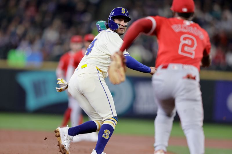Jun 2, 2024; Seattle, Washington, USA;  Seattle Mariners third baseman Josh Rojas (4) is caught on a rundown with Los Angeles Angels third baseman Luis Rengifo (2) chasing during the first at T-Mobile Park. Mandatory Credit: John Froschauer-USA TODAY Sports