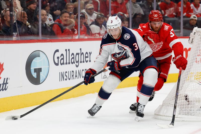 Nov 22, 2025; Detroit, Michigan, USA;  Columbus Blue Jackets center Charlie Coyle (3) skates with the puck defended by Detroit Red Wings left wing J.T. Compher (37) in the third period at Little Caesars Arena. Mandatory Credit: Rick Osentoski-Imagn Images