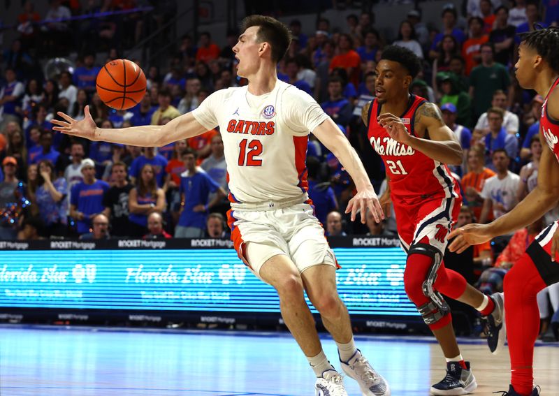 Feb 15, 2023; Gainesville, Florida, USA; Mississippi Rebels forward Robert Allen (21) fouls Florida Gators forward Colin Castleton (12) during the second half at Exactech Arena at the Stephen C. O'Connell Center. Mandatory Credit: Kim Klement-USA TODAY Sports