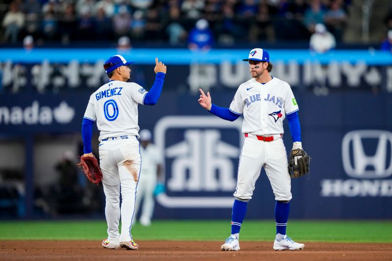 Mar 28, 2026; Toronto, Ontario, CAN;  Toronto Blue Jays second baseman Andrés Giménez (0) and third baseman Ernie Clement (22) celebrate making an out against the Athletics at Rogers Centre. Mandatory Credit: Kevin Sousa-Imagn Images