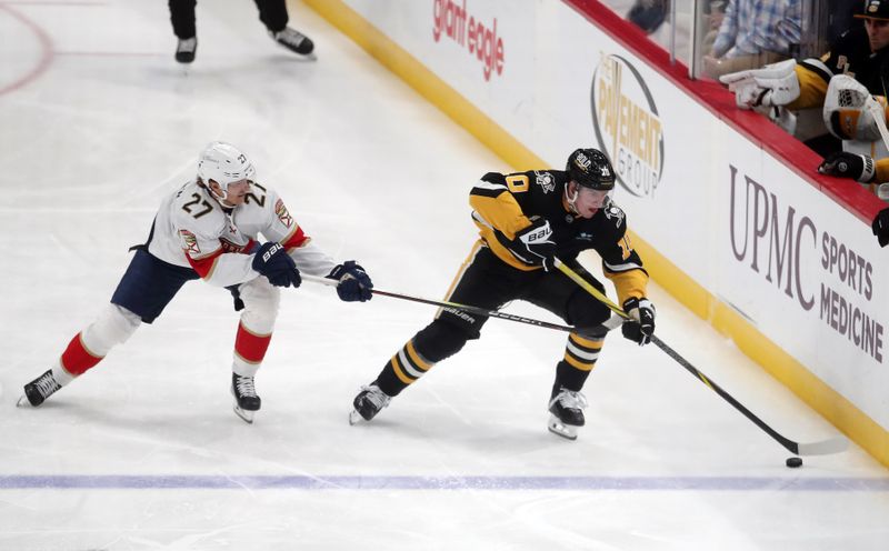 Dec 3, 2024; Pittsburgh, Pennsylvania, USA;  Pittsburgh Penguins left wing Drew O'Connor (10) moves the puck up ice against Florida Panthers center Eetu Luostarinen (27) during the first period at PPG Paints Arena. Mandatory Credit: Charles LeClaire-Imagn Images