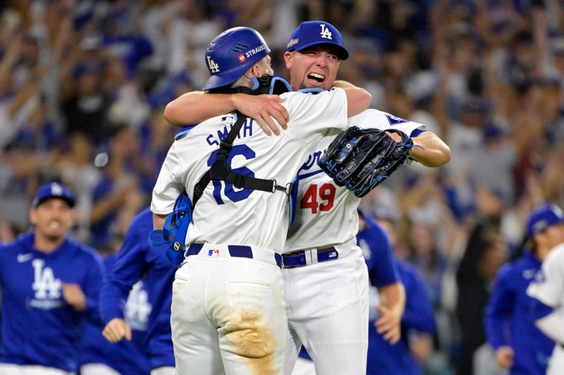 Oct 20, 2024; Los Angeles, California, USA; Los Angeles Dodgers pitcher Blake Treinen (49) celebrates with catcher Will Smith (16) after the final out to defeat the New York Mets in game six of the NLCS for the 2024 MLB playoffs at Dodger Stadium. Mandatory Credit: Jayne Kamin-Oncea-Imagn Images