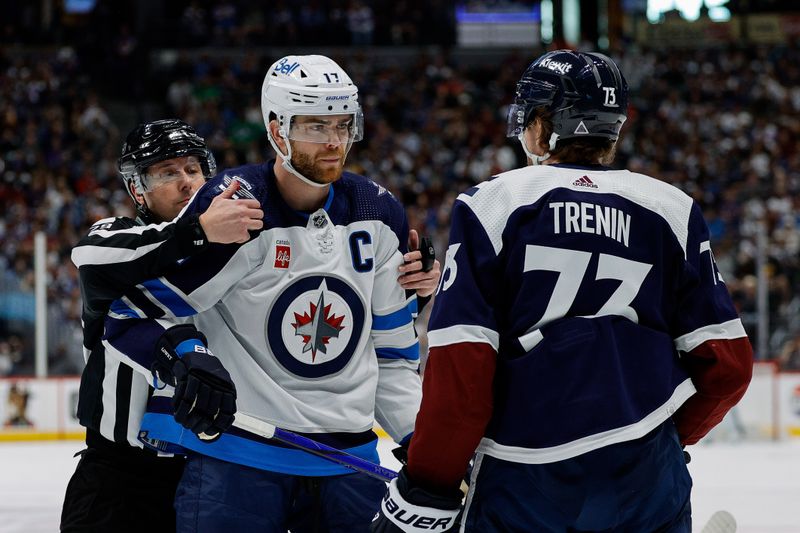 Apr 13, 2024; Denver, Colorado, USA; Linesman Kiel Murchison (79) holds Winnipeg Jets center Adam Lowry (17) as he eyes Colorado Avalanche center Yakov Trenin (73) in the first period at Ball Arena. Mandatory Credit: Isaiah J. Downing-USA TODAY Sports