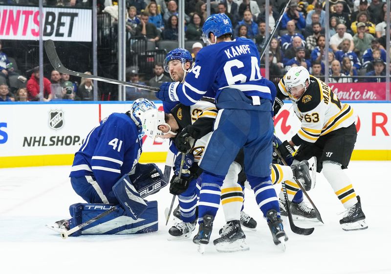 Nov 5, 2024; Toronto, Ontario, CAN; Boston Bruins center Charlie Coyle (13) battles with Toronto Maple Leafs center David Kampf (64) in front of goaltender Anthony Stolarz (41) during the second period at Scotiabank Arena. Mandatory Credit: Nick Turchiaro-Imagn Imagess