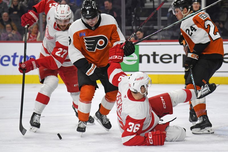 Jan 21, 2025; Philadelphia, Pennsylvania, USA; Detroit Red Wings center Michael Rasmussen (27) and Philadelphia Flyers defenseman Jamie Drysdale (9) battle for the puck with right wing Christian Fischer (36) during the second period at Wells Fargo Center. Mandatory Credit: Eric Hartline-Imagn Images