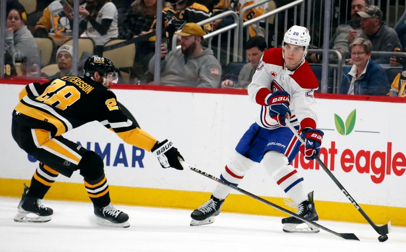 Feb 22, 2024; Pittsburgh, Pennsylvania, USA; Montreal Canadiens left wing Juraj Slafkovsky (20) passes the puck around Pittsburgh Penguins defenseman Marcus Pettersson (28) during the third period at PPG Paints Arena. The Penguins won 4-1. Mandatory Credit: Charles LeClaire-USA TODAY Sports