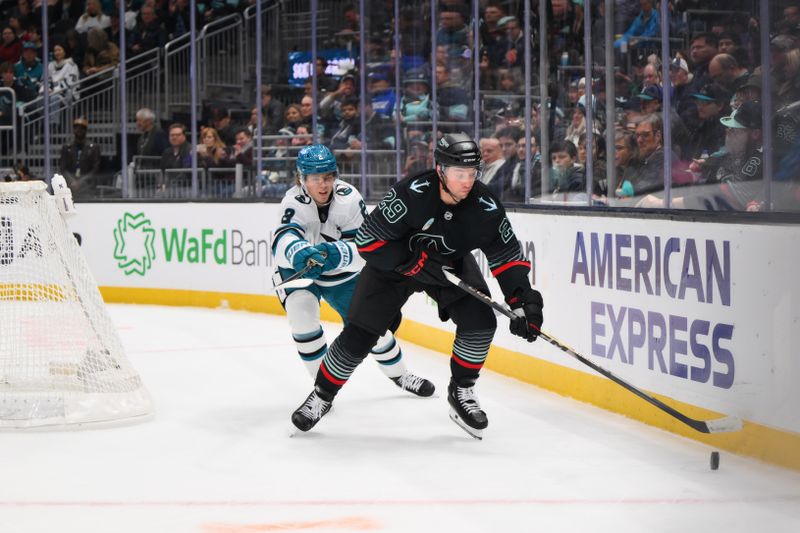 Nov 5, 2025; Seattle, Washington, USA; Seattle Kraken defenseman Vince Dunn (29) plays the puck while defended by San Jose Sharks center Will Smith (2) during the first period at Climate Pledge Arena. Mandatory Credit: Steven Bisig-Imagn Images