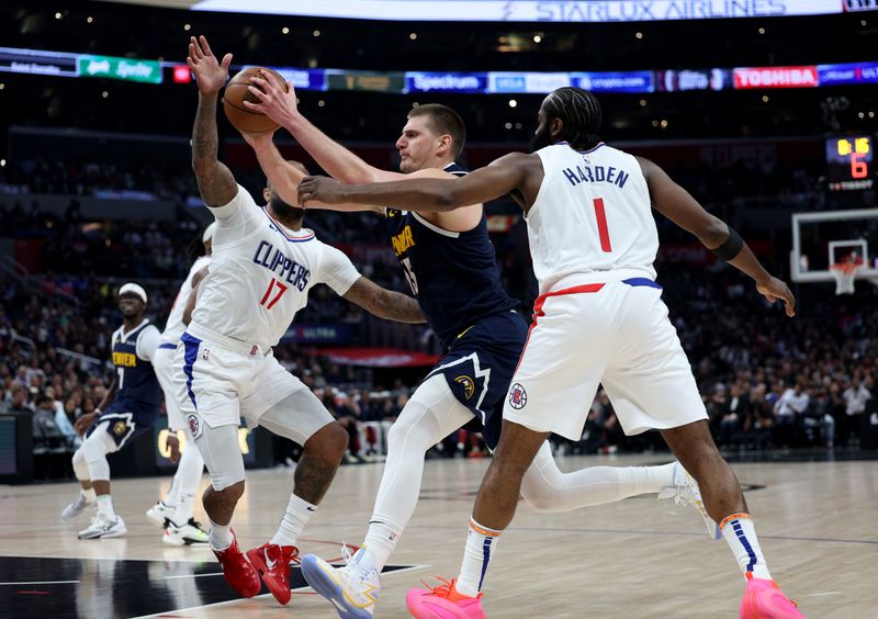 LOS ANGELES, CALIFORNIA - APRIL 04: Nikola Jokic #15 of the Denver Nuggets drives to the basket between James Harden #1 and P.J. Tucker #17 of the LA Clippers during a 102-100 Clippers win at Crypto.com Arena on April 04, 2024 in Los Angeles, California. User is consenting to the terms and conditions of the Getty Images License Agreement. (Photo by Harry How/Getty Images)