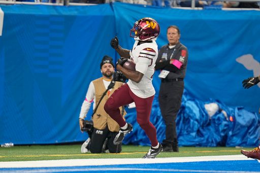 Washington Commanders safety Quan Martin (20) returns a 40-yard interception for a touchdown against the Detroit Lions during the first half of an NFL football divisional playoff game, Saturday, Jan. 18, 2025, in Detroit. (AP Photo/Seth Wenig)