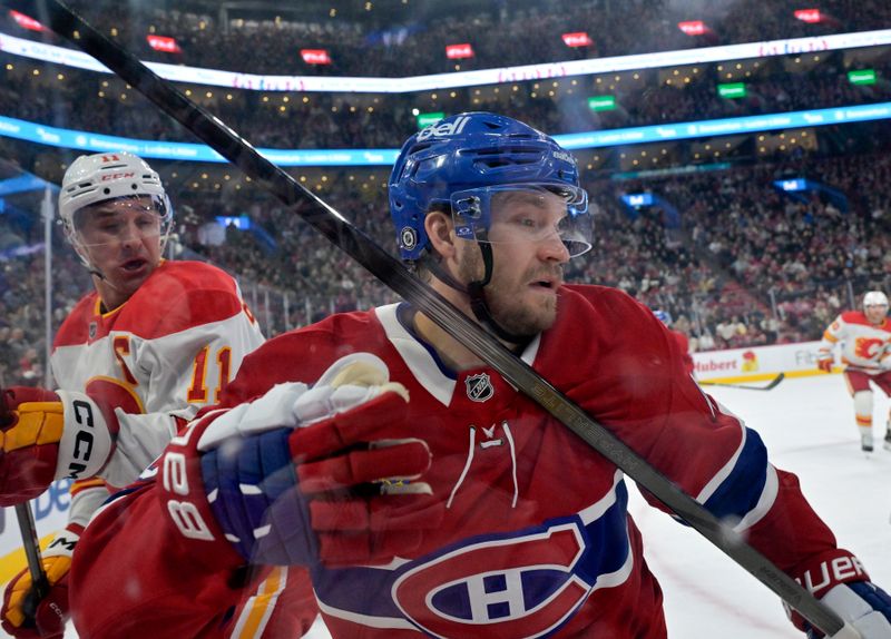 Nov 5, 2024; Montreal, Quebec, CAN; Calgary Flames forward Mikael Backlund (11) and Montreal Canadiens forward Joel Armia (40) battle along the boards during the third period at the Bell Centre. Mandatory Credit: Eric Bolte-Imagn Images