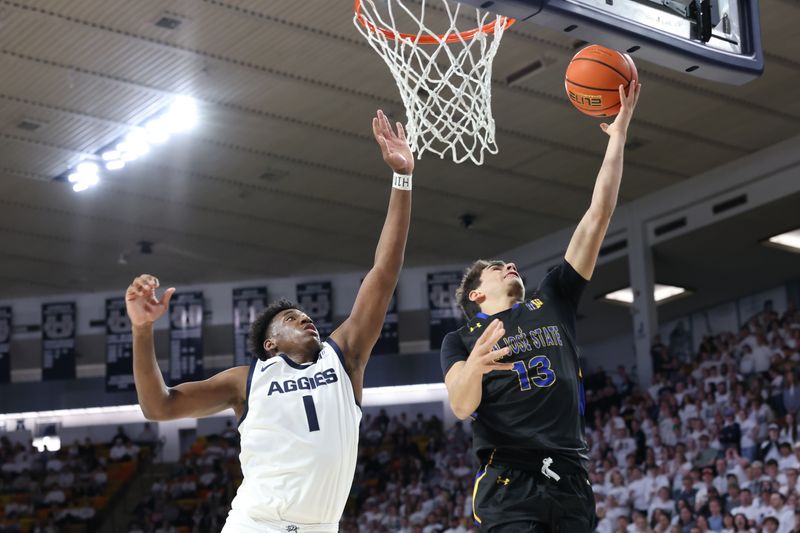 Jan 30, 2024; Logan, Utah, USA; San Jose State Spartans guard Alvaro Cardenas (13) lays the all up against Utah State Aggies forward Great Osobor (1) during the first half at Dee Glen Smith Spectrum. Mandatory Credit: Rob Gray-USA TODAY Sports