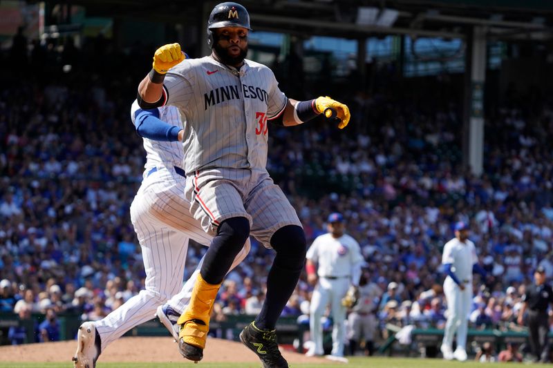 Aug 7, 2024; Chicago, Illinois, USA; Minnesota Twins first baseman Carlos Santana (30) is safe at first base as Chicago Cubs first baseman Michael Busch (29) tries to make a tag during the sixth inning at Wrigley Field. Mandatory Credit: David Banks-USA TODAY Sports