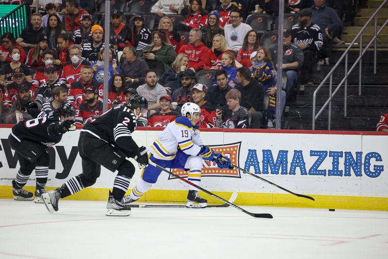 Oct 27, 2023; Newark, New Jersey, USA; Buffalo Sabres center Peyton Krebs (19) plays the puck against New Jersey Devils defenseman Brendan Smith (2) during the second period at Prudential Center. Mandatory Credit: Vincent Carchietta-USA TODAY Sports