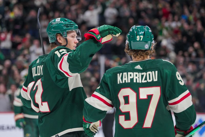 Apr 2, 2024; Saint Paul, Minnesota, USA; Minnesota Wild left wing Matt Boldy (12) celebrates his goal with center Dmitry Ovchinnikov (97) against the Ottawa Senators in the second period at Xcel Energy Center. Mandatory Credit: Brad Rempel-USA TODAY Sports