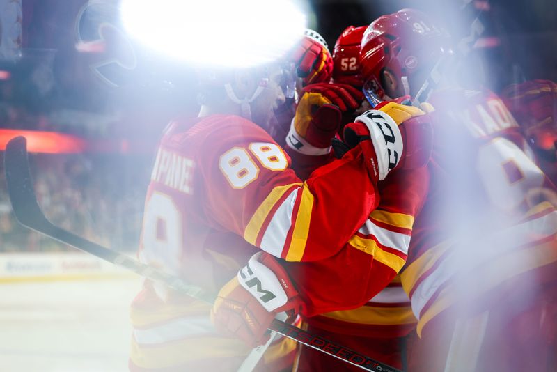 Feb 22, 2024; Calgary, Alberta, CAN; Calgary Flames center Nazem Kadri (91) celebrates his goal with teammates against the Boston Bruins during the overtime period at Scotiabank Saddledome. Mandatory Credit: Sergei Belski-USA TODAY Sports