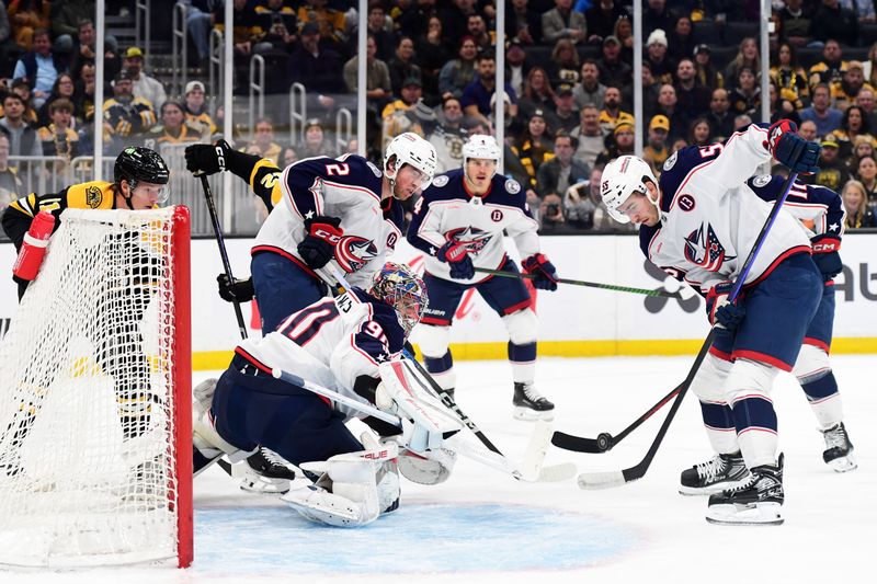 Nov 18, 2024; Boston, Massachusetts, USA;  Columbus Blue Jackets defenseman David Jiricek (55) tries to gain control of the puck in front of goaltender Elvis Merzlikins (90) during the first period against the Boston Bruins at TD Garden. Mandatory Credit: Bob DeChiara-Imagn Images