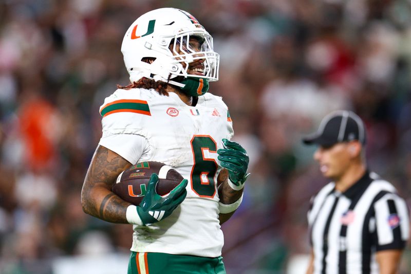 Sep 21, 2024; Tampa, Florida, USA; Miami Hurricanes running back Damien Martinez (6) scores a touchdown against the South Florida Bulls in the third quarter at Raymond James Stadium. Mandatory Credit: Nathan Ray Seebeck-Imagn Images