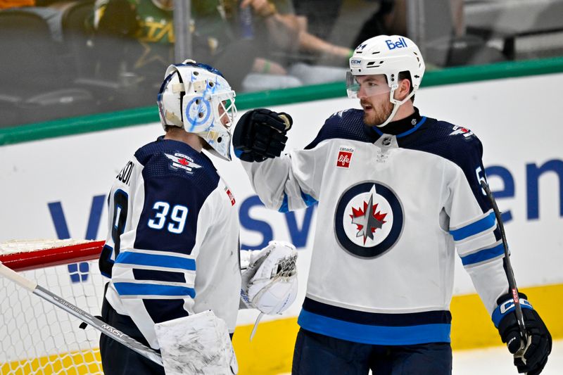 Apr 11, 2024; Dallas, Texas, USA; Winnipeg Jets goaltender Laurent Brossoit (39) and defenseman Dylan Samberg (54) celebrate on the ice after the Jets defeat the Dallas Stars at the American Airlines Center. Mandatory Credit: Jerome Miron-USA TODAY Sports