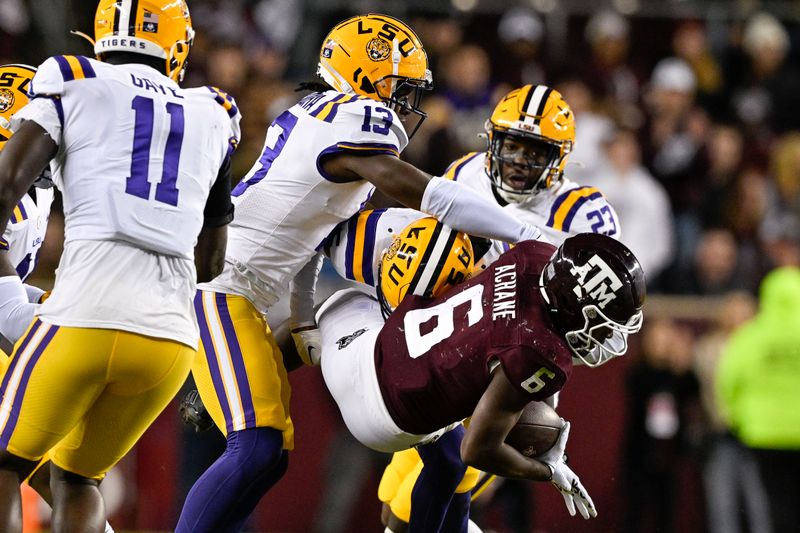 Nov 26, 2022; College Station, Texas, USA; Texas A&M Aggies running back Devon Achane (6) is tackled by LSU Tigers safety Joe Foucha (13) and safety Jay Ward (5) during the first quarter at Kyle Field. Mandatory Credit: Jerome Miron-USA TODAY Sports