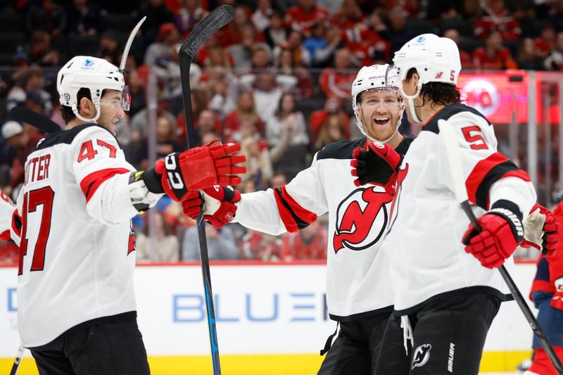 Nov 23, 2024; Washington, District of Columbia, USA; New Jersey Devils defenseman Brenden Dillon (5) celebrates with teammates after scoring a goal against the Washington Capitals in the second period at Capital One Arena. Mandatory Credit: Geoff Burke-Imagn Images