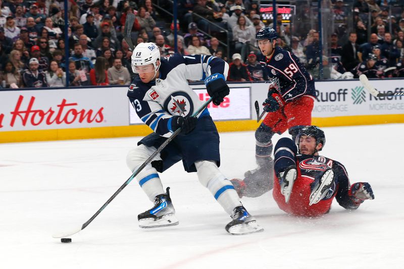 Nov 1, 2024; Columbus, Ohio, USA; Winnipeg Jets center Gabriel Vilardi (13) carries the puck as Columbus Blue Jackets defenseman Zach Werenski (8) slides on the ice during the first period at Nationwide Arena. Mandatory Credit: Russell LaBounty-Imagn Images