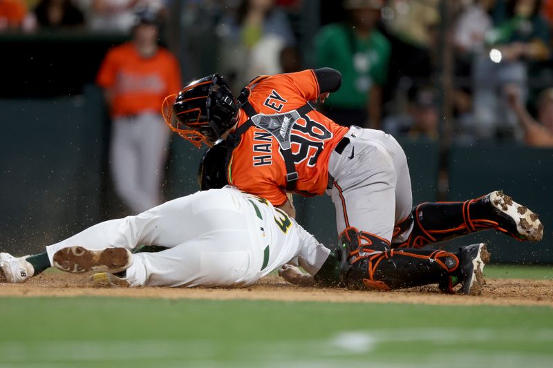 Jun 7, 2025; West Sacramento, California, USA; Baltimore Orioles catcher Maverick Handley (98) covers home plate as Athletics left fielder JJ Bleday (33) slides home during the fifth inning at Sutter Health Park. Mandatory Credit: Dennis Lee-Imagn Images