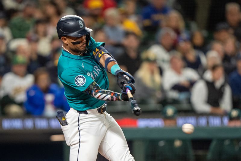 Sep 28, 2024; Seattle, Washington, USA; Seattle Mariners centerfielder Julio Rodriguez (44) hits a single during the fifth inning at T-Mobile Park. Mandatory Credit: Stephen Brashear-Imagn Images