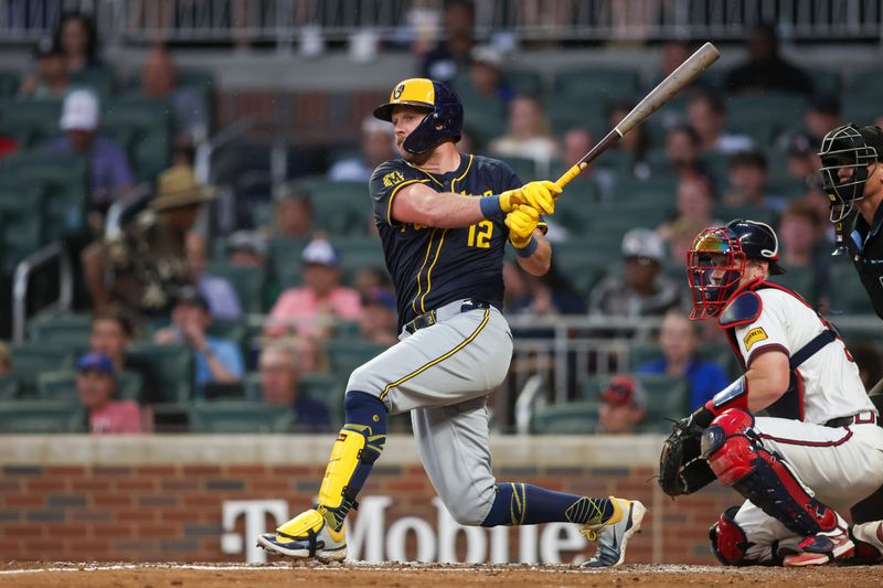 Aug 7, 2024; Atlanta, Georgia, USA; Milwaukee Brewers first baseman Rhys Hoskins (12) hits a single against the Atlanta Braves in the fifth inning at Truist Park. Mandatory Credit: Brett Davis-USA TODAY Sports