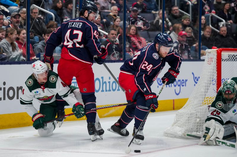 Jan 6, 2024; Columbus, Ohio, USA;  Columbus Blue Jackets right winger Mathieu Olivier (24) skates with the puck as center Alexandre Texier (42) battles for space against Minnesota Wild defenseman Jon Merrill (4) in the first period at Nationwide Arena. Mandatory Credit: Aaron Doster-USA TODAY Sports