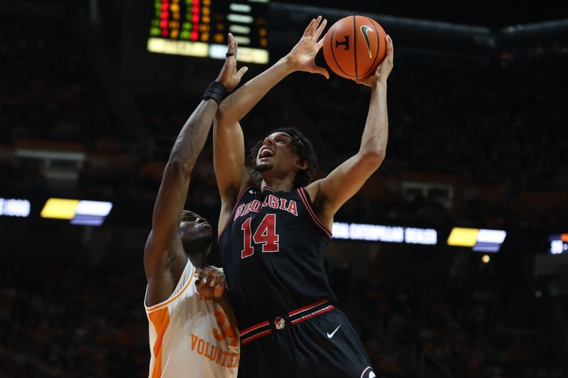 Jan 15, 2025; Knoxville, Tennessee, USA; Georgia Bulldogs forward Asa Newell (14) shoots against Tennessee Volunteers forward Felix Okpara (34) during the second half at Thompson-Boling Arena at Food City Center. Mandatory Credit: Randy Sartin-Imagn Images