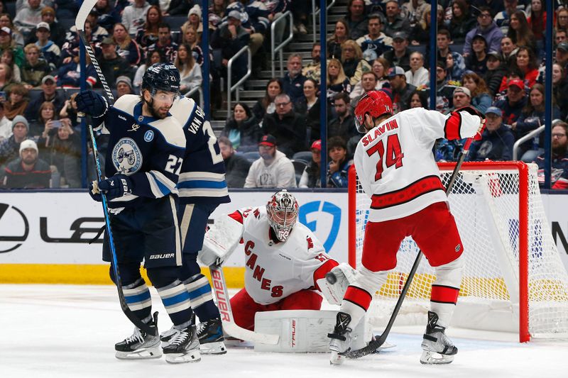 Dec 31, 2024; Columbus, Ohio, USA; Carolina Hurricanes goalie Pyotr Kochetkov (52) makes a glove save as Columbus Blue Jackets center Zach Aston-Reese (27) looks for a rebound during the third period at Nationwide Arena. Mandatory Credit: Russell LaBounty-Imagn Images