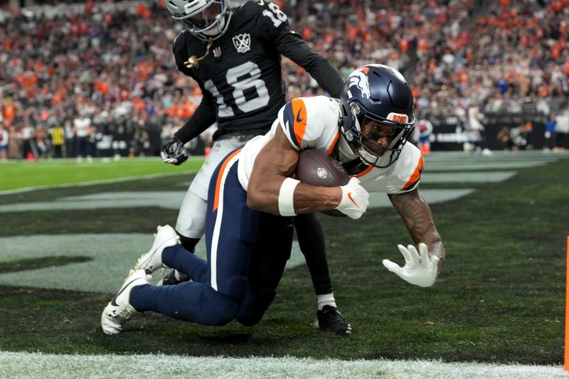 Denver Broncos wide receiver Courtland Sutton pulls in a touchdown pass as Las Vegas Raiders cornerback Jack Jones (18) defends during the second half of an NFL football game, Sunday, Nov. 24, 2024, in Las Vegas. (AP Photo/Rick Scuteri)