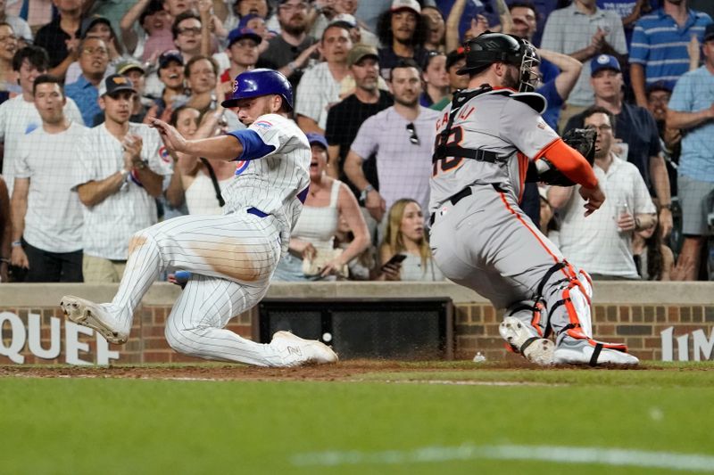 Jun 18, 2024; Chicago, Illinois, USA; Chicago Cubs first base Michael Busch (29) is safe at home plate as San Francisco Giants catcher Curt Casali (18) makes a late tag during the eighth inning at Wrigley Field. Mandatory Credit: David Banks-USA TODAY Sports