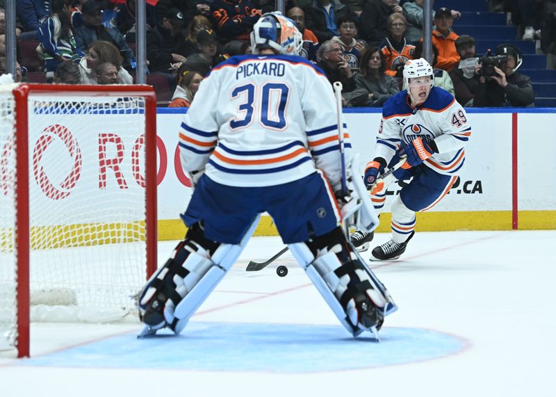 Oct 26, 2025; Vancouver, British Columbia, CAN; Edmonton Oilers defenseman Ty Emberson (49) skates with the puck passed goaltender Calvin Pickard (30)  during the second period against the Vancouver Canucks  at Rogers Arena. Mandatory Credit: Simon Fearn-Imagn Images