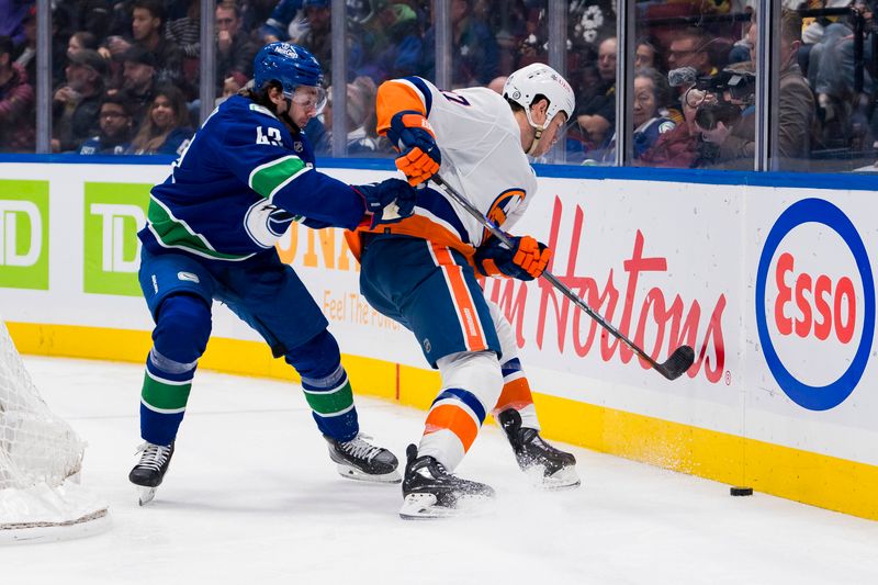 Nov 15, 2023; Vancouver, British Columbia, CAN; Vancouver Canucks defenseman Quinn Hughes (43) battles with New York Islanders forward Matt Martin (17) in the first period at Rogers Arena. Mandatory Credit: Bob Frid-USA TODAY Sports