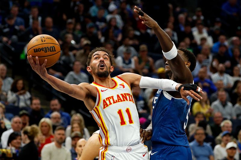 MINNEAPOLIS, MINNESOTA - APRIL 12: Trae Young #11 of the Atlanta Hawks goes up for a shot against Anthony Edwards #5 of the Minnesota Timberwolves in the first quarter at Target Center on April 12, 2024 in Minneapolis, Minnesota. NOTE TO USER: User expressly acknowledges and agrees that, by downloading and or using this photograph, User is consenting to the terms and conditions of the Getty Images License Agreement. (Photo by David Berding/Getty Images)