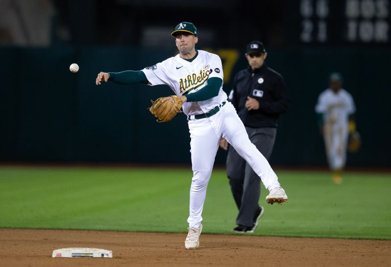 Sep 15, 2023; Oakland, California, USA; Oakland Athletics shortstop Kevin Smith (4) leaves his feet to throw out San Diego Padres catcher Luis Campusano at first base during the ninth inning at Oakland-Alameda County Coliseum. Mandatory Credit: D. Ross Cameron-USA TODAY Sports