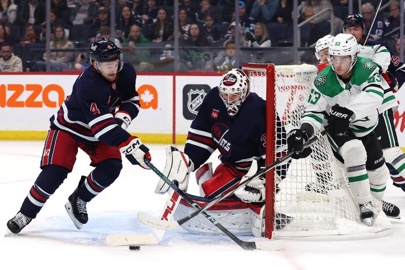 Nov 9, 2024; Winnipeg, Manitoba, CAN; Winnipeg Jets goaltender Connor Hellebuyck (37) makes a poke save against Dallas Stars center Wyatt Johnston (53) in the first period at Canada Life Centre. Mandatory Credit: James Carey Lauder-Imagn Images