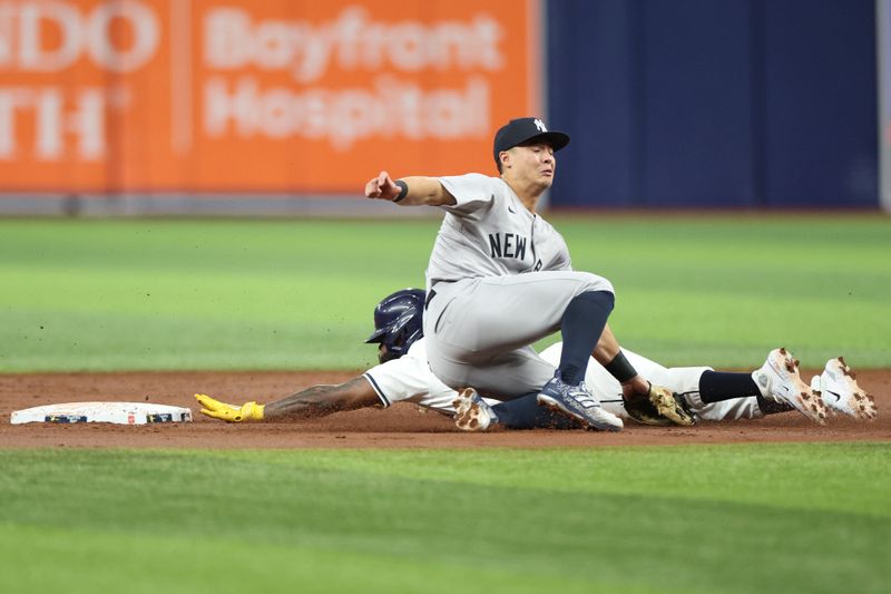 Jul 10, 2024; St. Petersburg, Florida, USA;  Tampa Bay Rays outfielder Randy Arozarena (56) is caught stealing by New York Yankees shortstop Anthony Volpe (11) in the second inning at Tropicana Field. Mandatory Credit: Nathan Ray Seebeck-USA TODAY Sports