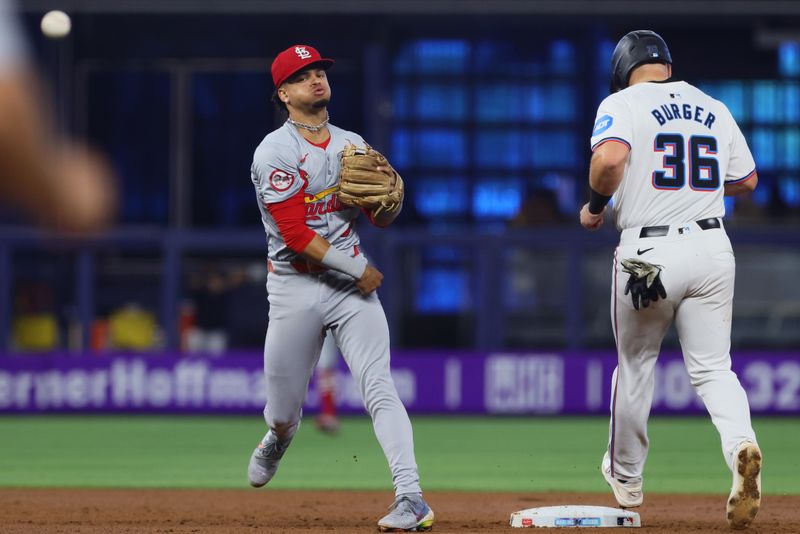 Jun 19, 2024; Miami, Florida, USA; St. Louis Cardinals shortstop Masyn Winn (0) turns a double play against the Miami Marlins during the first inning at loanDepot Park. Mandatory Credit: Sam Navarro-USA TODAY Sports