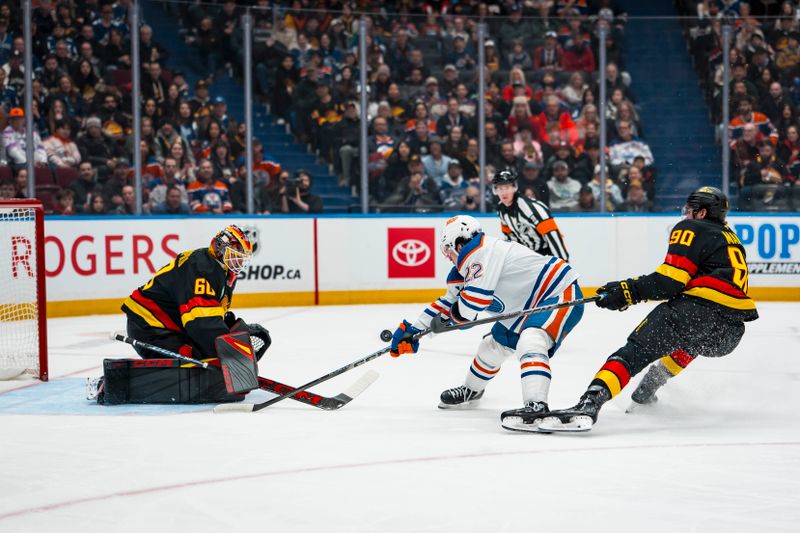 Jan 17, 2026; Vancouver, British Columbia, CAN; Vancouver Canucks defenseman Victor Mancini (90) watches as goalie Nikita Tolopilo (60) makes a save on Edmonton Oilers forward Matt Savoie (22) in the first period at Rogers Arena. Mandatory Credit: Bob Frid-Imagn Images