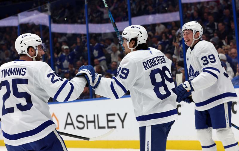 Nov 30, 2024; Tampa, Florida, USA;Toronto Maple Leafs left wing Nicholas Robertson (89) its congratulated by defenseman Conor Timmins (25) and center Fraser Minten (39) after he scored a goal against the Tampa Bay Lightning  during the second period at Amalie Arena. Mandatory Credit: Kim Klement Neitzel-Imagn Images