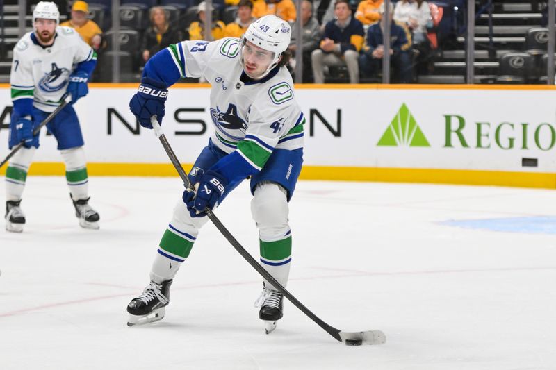 Oct 23, 2025; Nashville, Tennessee, USA;  Vancouver Canucks defenseman Quinn Hughes (43) passes the puck against the Nashville Predators during the third period at Bridgestone Arena. Mandatory Credit: Steve Roberts-Imagn Images
