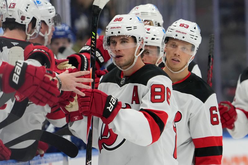 Oct 21, 2025; Toronto, Ontario, CAN; New Jersey Devils forward Jack Hughes (86) is congratulated after scoring his third goal against the Toronto Maple Leafs during the third period at Scotiabank Arena. Mandatory Credit: John E. Sokolowski-Imagn Images