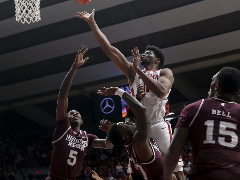 Feb 3, 2024; Tuscaloosa, Alabama, USA;  Alabama forward Mohamed Wague (11) shoots in the lane over Mississippi State guard Shawn Jones Jr. (5), Mississippi State guard Trey Fort (11) and Mississippi State forward Jimmy Bell Jr. (15) at Coleman Coliseum. Mandatory Credit: Gary Cosby Jr.-USA TODAY Sports